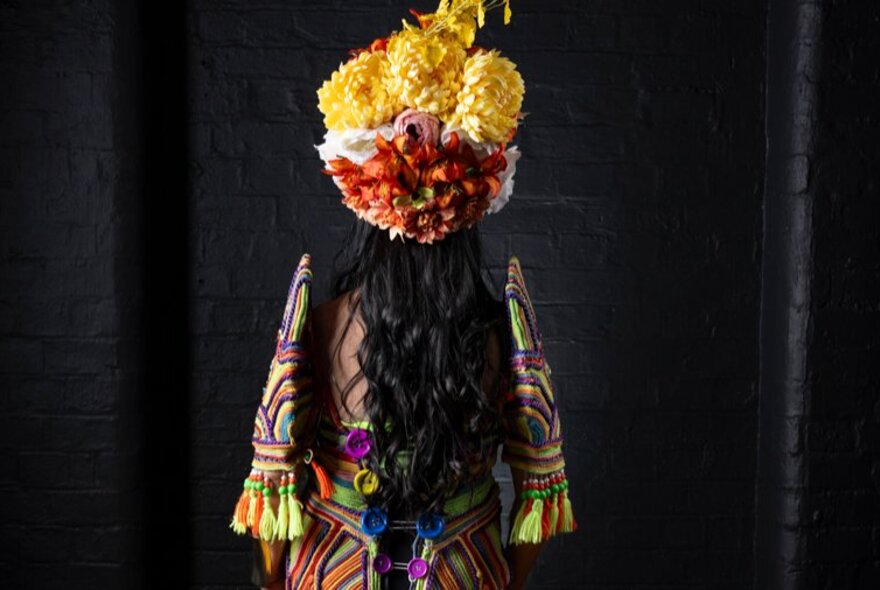 A Filipino Flores de Mayo pageant queen wearing an intricately woven and brightly coloured traditional dress and a floral headdress. 