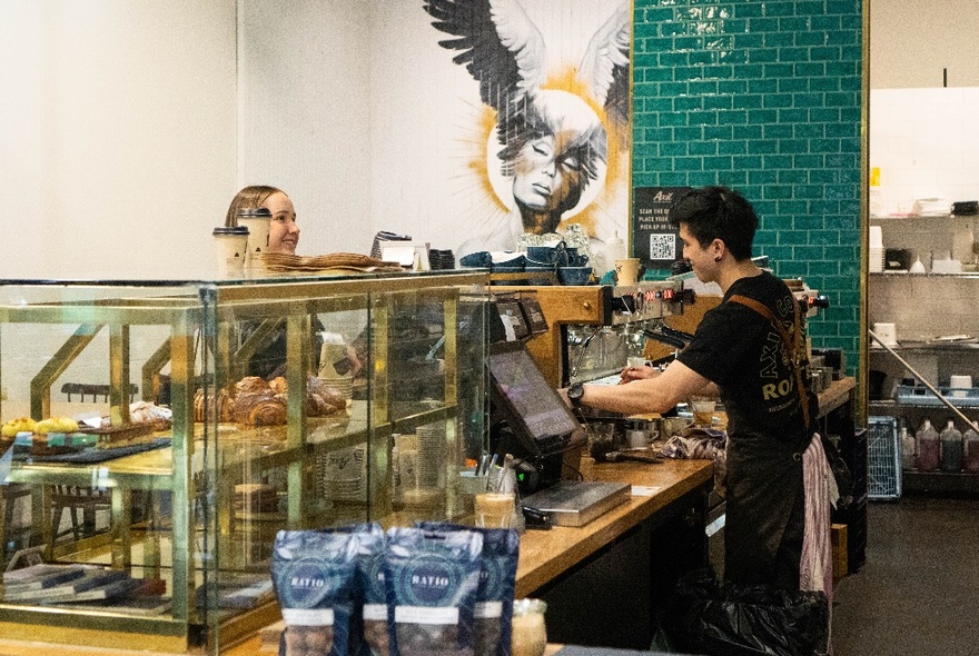 Interior of Axil Coffee in Southern Cross Lane, with a barista  behind the counter serving a customer.
