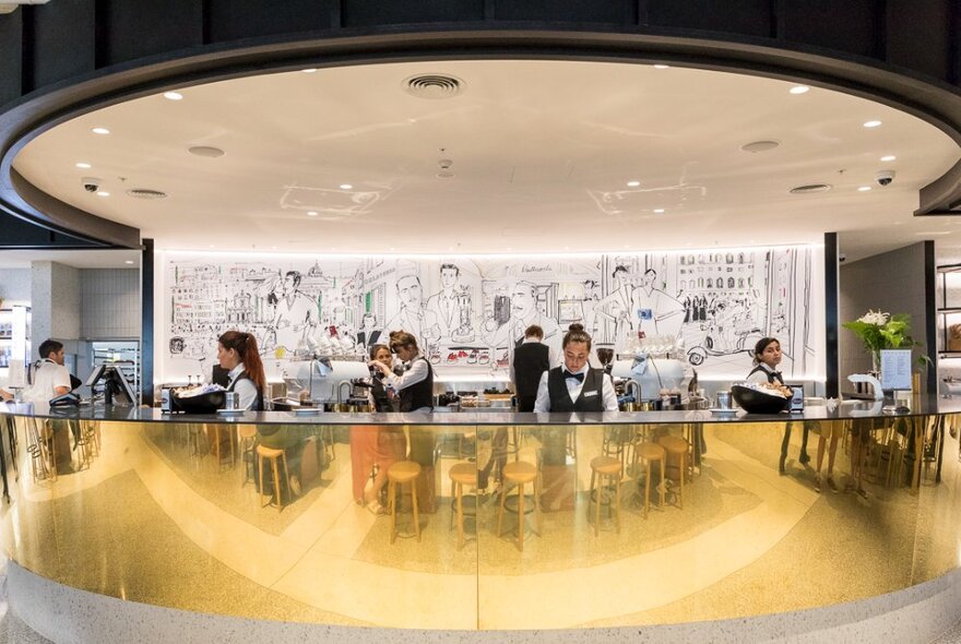 The curved counter of Brunetti Oro Flinders Lane, with staff serving and making coffees.