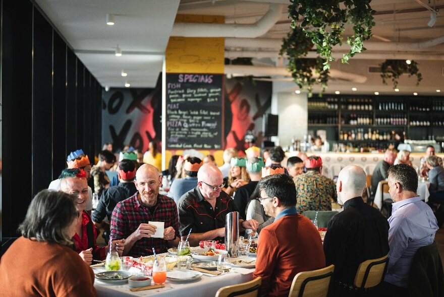 Interior of Sassy Restaurant with people seated at tables, socialising, eating and drinking. 