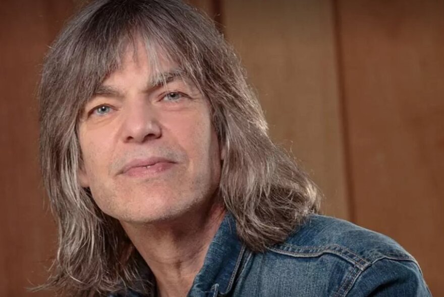 Musician Mike Stern, wearing a denim shirt with long grey hair.