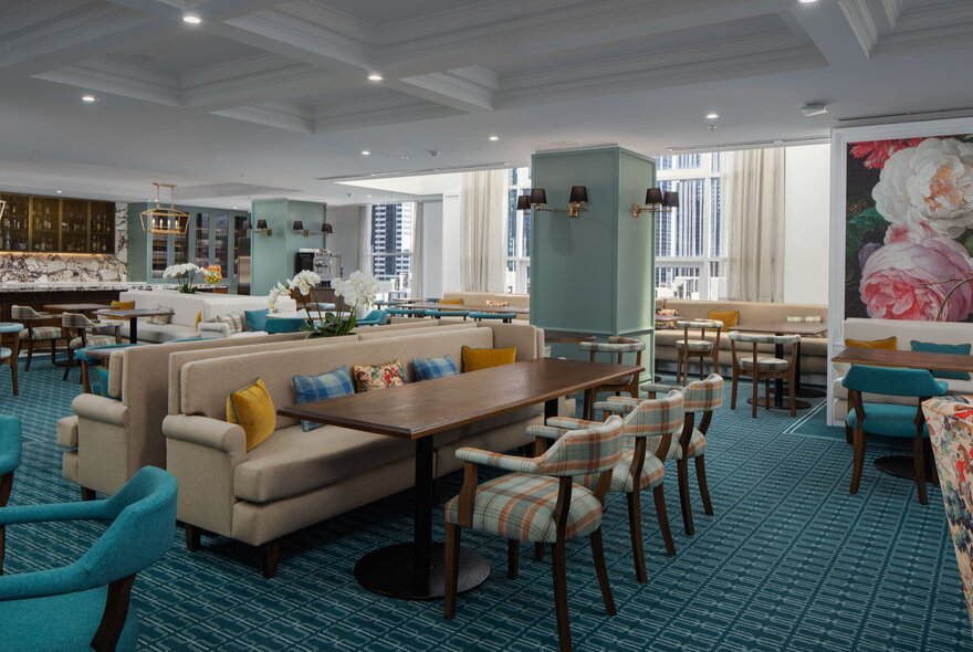 The Elevate Club Lounge at Pullman Melbourne City Centre, with chairs, armchairs and dining tables, and blue carpet.