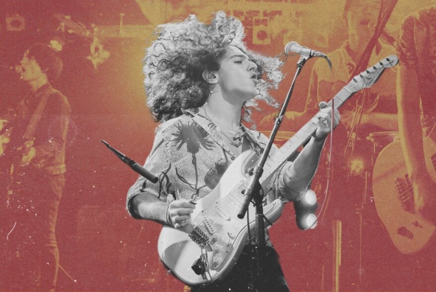 Musician Ben Swissa playing an electric guitar with his long curly hair swirling around his head, performing on stage, against a sepia toned backdrop of a band.