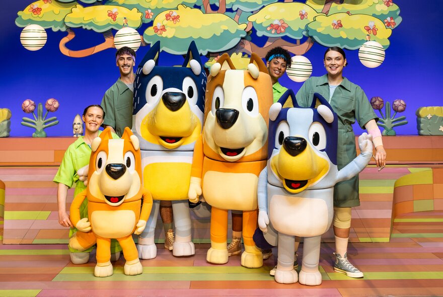 Bluey stage show human and puppet cast with tree background.