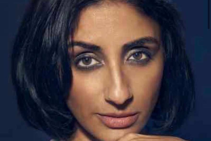 Close up portrait of comedian, Kiran Deol, with black-rimmed eyes and her hair in a short black bob.