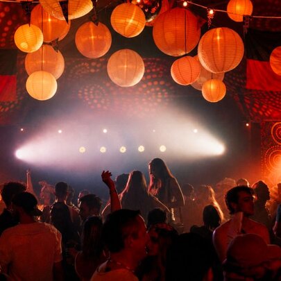 A darkened nightclub space with chinese lanterns and aboriginal artwork patterns on the wall and Aboriginal flags hanging from the ceiling.