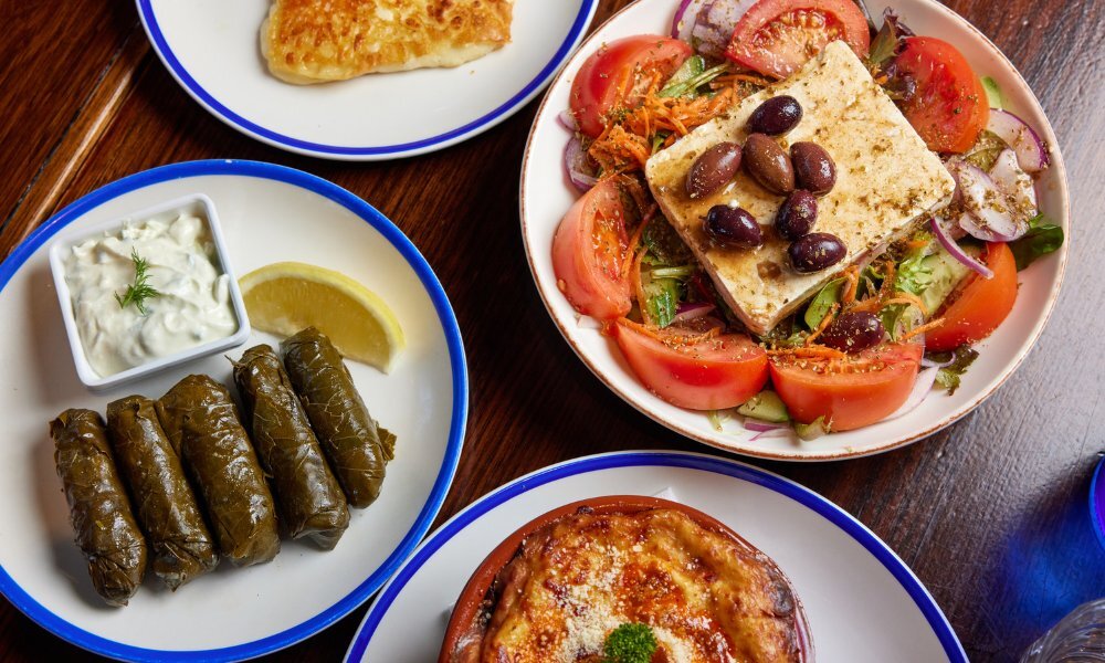 Top down image of different Greek dishes.