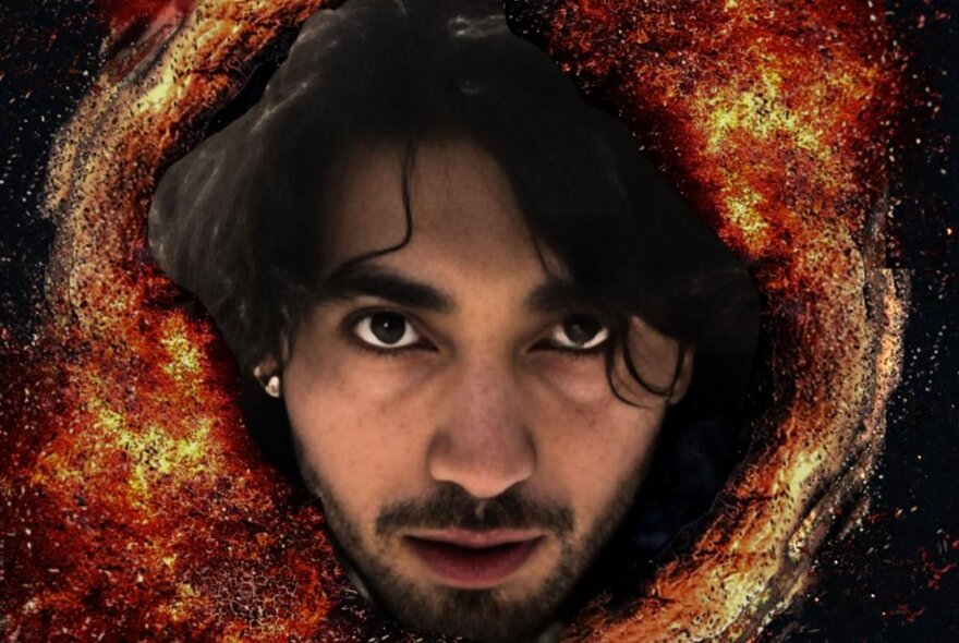An Indonesian-man's face bursting through a fiery galaxy.