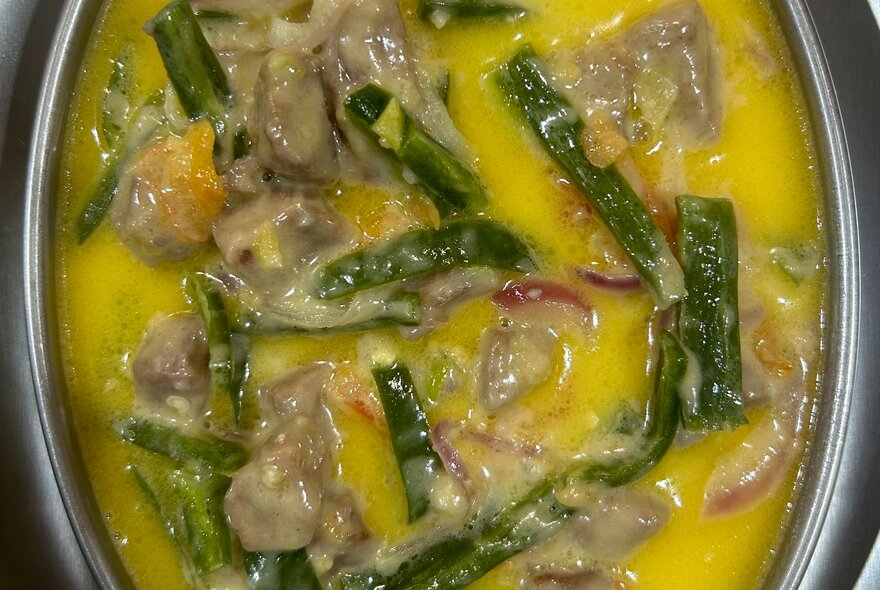 A Bhutanese vegetable and dried beef stew in a yellow sauce, seen from above.