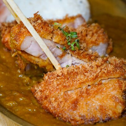 Japanese crumbed chicken on top of a curry dish.