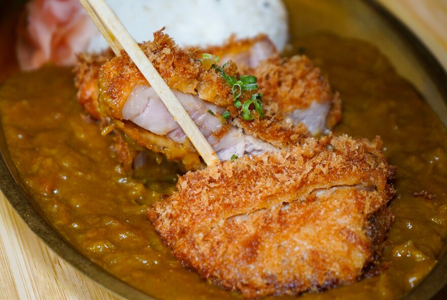 Japanese crumbed chicken on top of a curry dish.