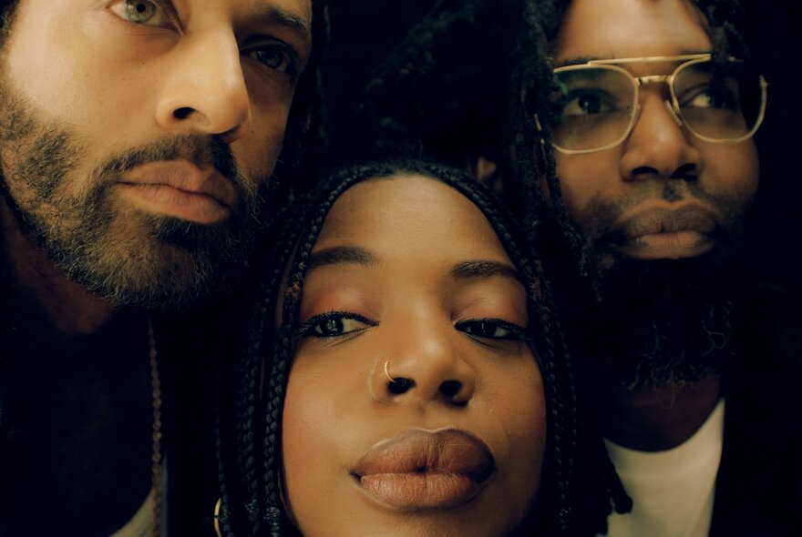 A close up portrait of three jazz musicians each with serious, non-smiling expressions.