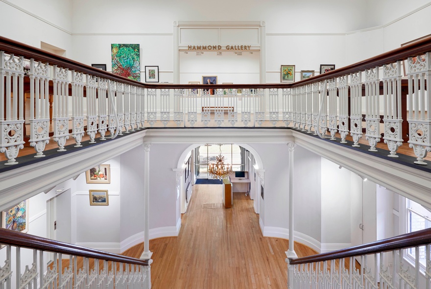 The interior of the Victorian Artist Society building showing two storeys and a white balcony.