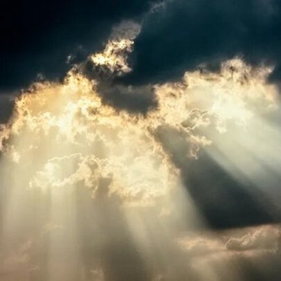 Beams of sunlight escaping through dark clouds.