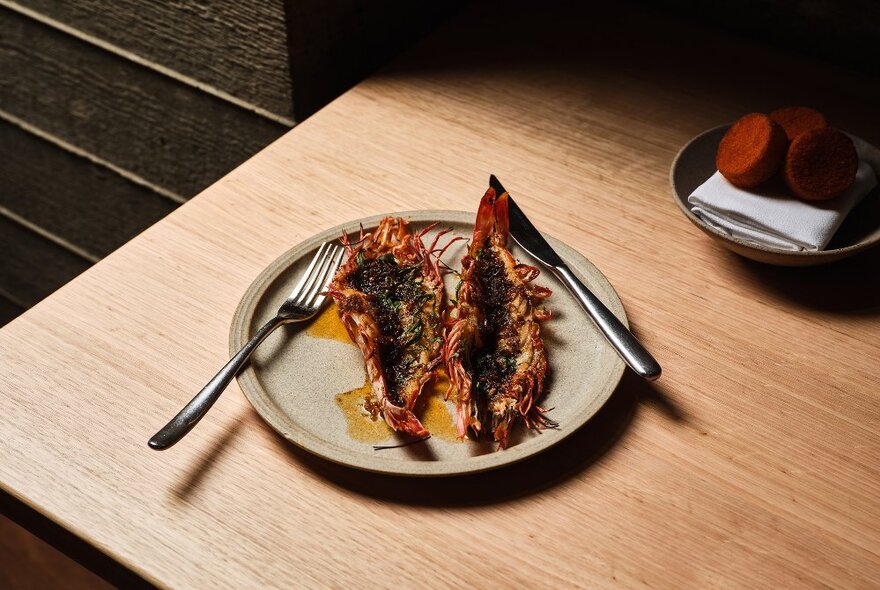 A plate and cutlery featuring grilled seafood.