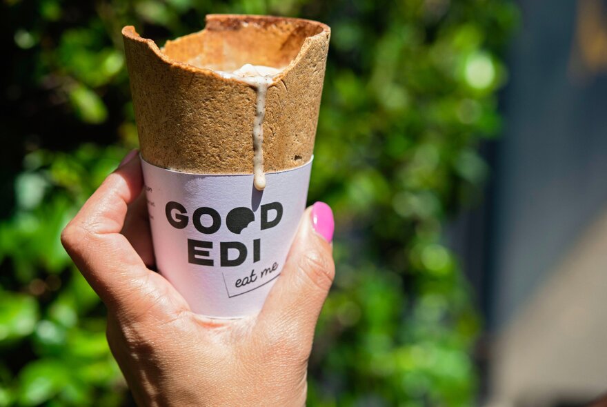 Hand holding a recycled branded cup.