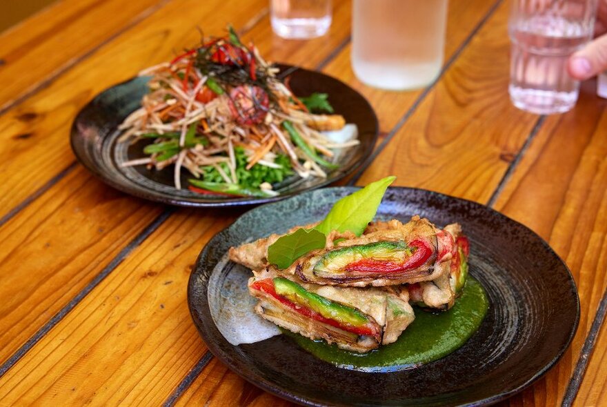 Two colourful Indian restaurant dishes. 