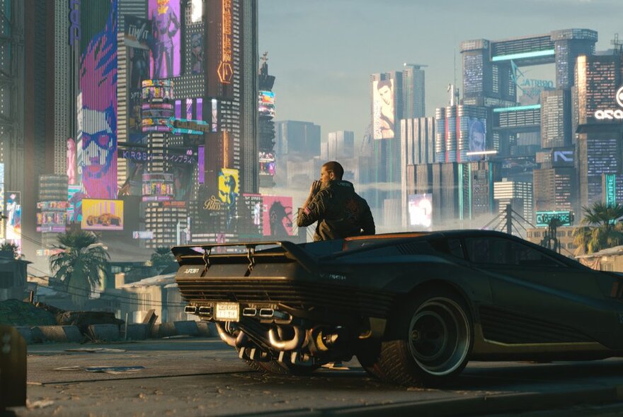 A still from the movie Blade Runner 2049 with a man leaning against a futuristic car, against a backdrop of a city of bright skyscrapers and buildings.