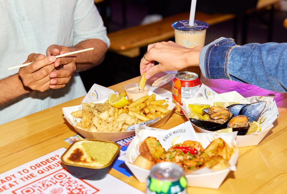 Two friends are eating chips and mussels