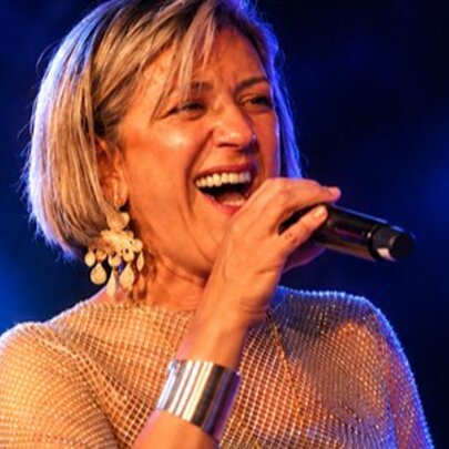 Singer Noria Letts performing live on stage, singing into a microphone.
