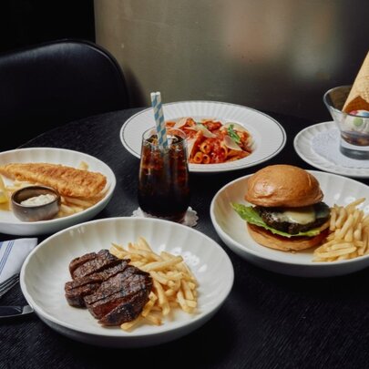 Kids meals of burgers and fries with party hats and drinks.