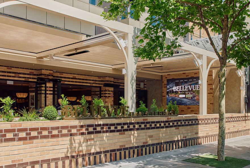 The external facade of Bellevue Bar and Terrace with a low brick fence in front of the riverfront terrace.