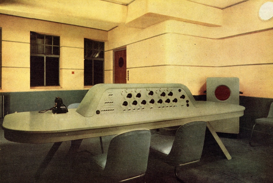 The dramatic control room with yellow walls, and central control panel with chairs, designed by modernist architect Wells Coates of BBC Broadcasting House in London.