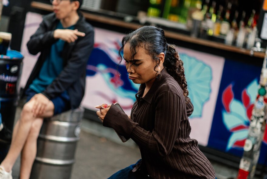 A young woman in a brown top, dancing.