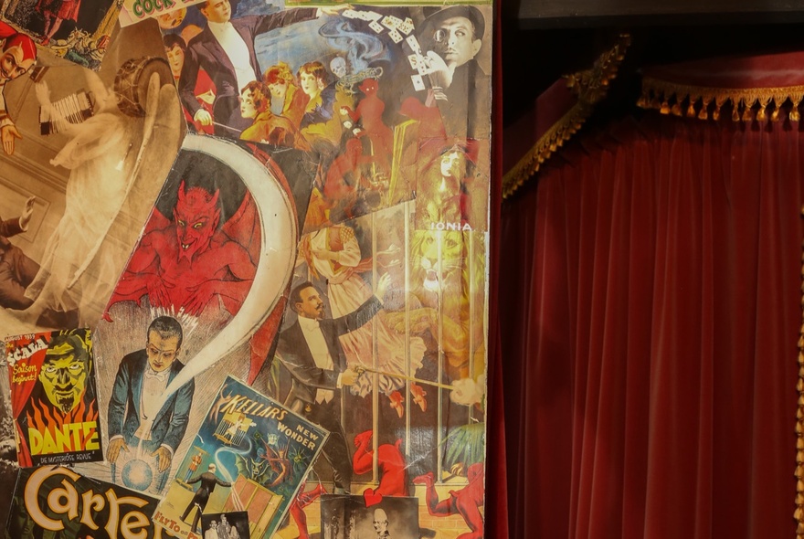 Velvet curtains and screen with vintage magic postcards and posters.
