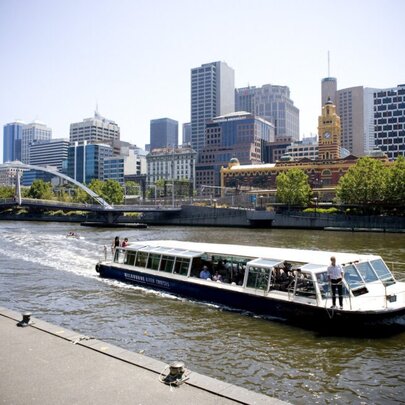 Sightseeing boat on the Yarra River with city buildings in the background.