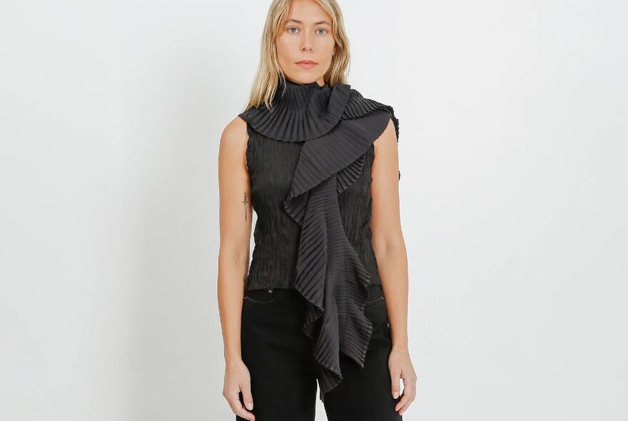 A blonde woman wearing a black pleated scarf.