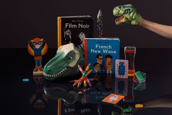 Collection of film-related children's books and Godzilla toys.