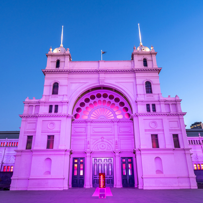 The Royal Exhibition Building lit up in pink lights.