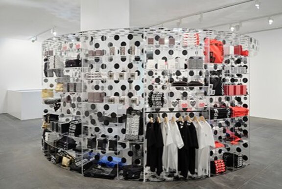 Clothing and accessories displayed on a clear and black polka dot circular display.