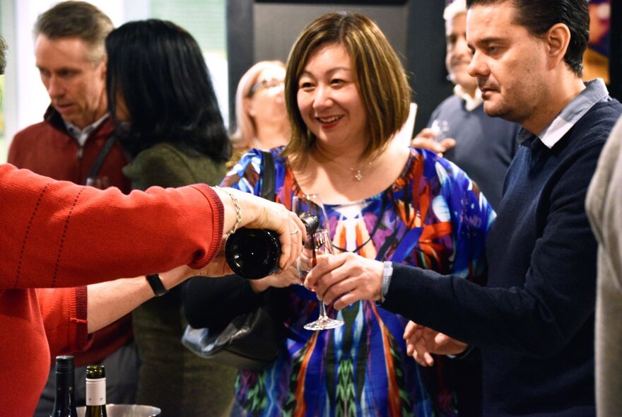 People tasting wines at a social event.