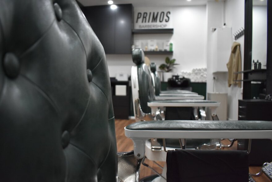 A low cropped view of a line of barber's chairs in a salon.