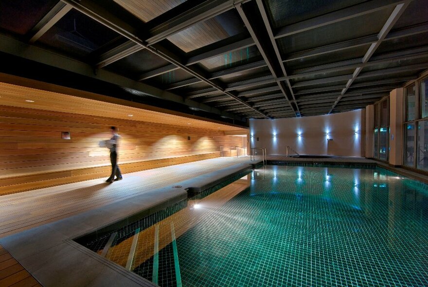 The hotel's indoor pool, with underwater lights illuminating the small green pool tiles.