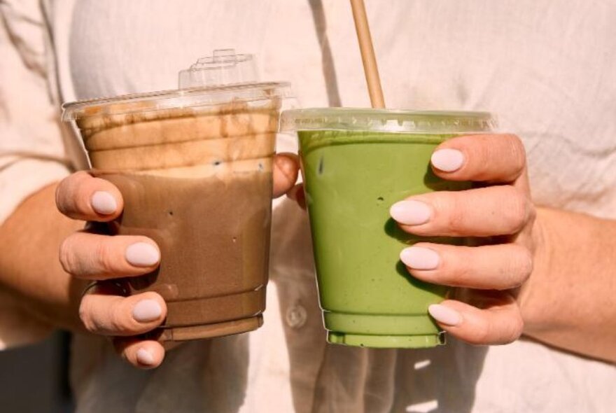 Two drinks being held in seperate hands