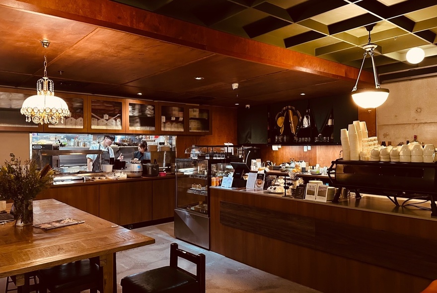 Warm wooden interior of Omo cafe, showing kitchen area and the service counter.