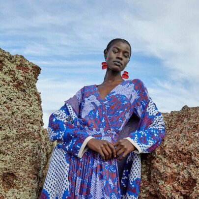 Woman wearing a blue dress and red earrings.