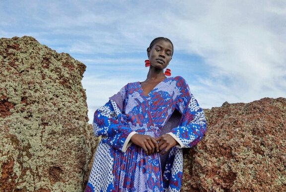 Woman wearing a blue dress and red earrings.