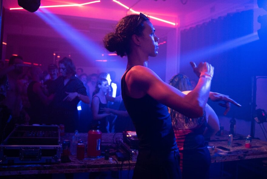 People in a dark space at night, dancing and listening to music.