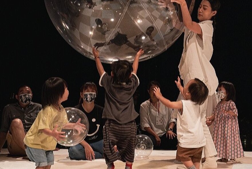 Children playing with a massive bubble-shaped prop.
