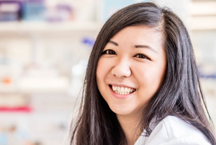 Portrait of a smiling woman with straight, dark hair.
