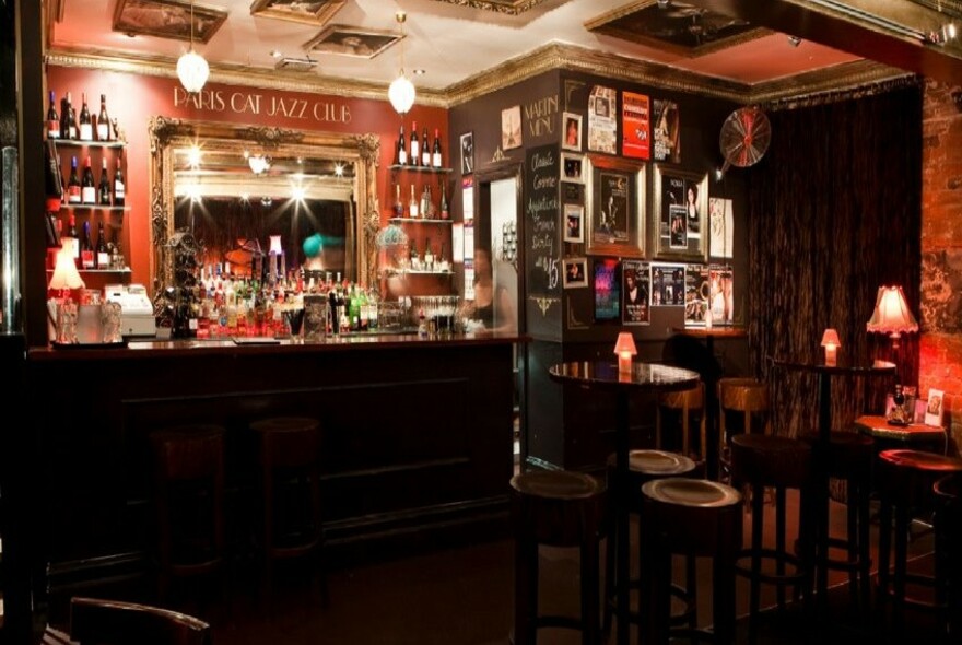 Paris Cat bar and small tables with red lamps on them.