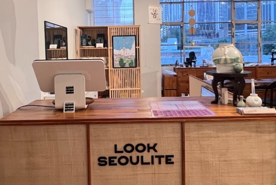 Retail store counter with signage and point of sale computer, with city views in the background.