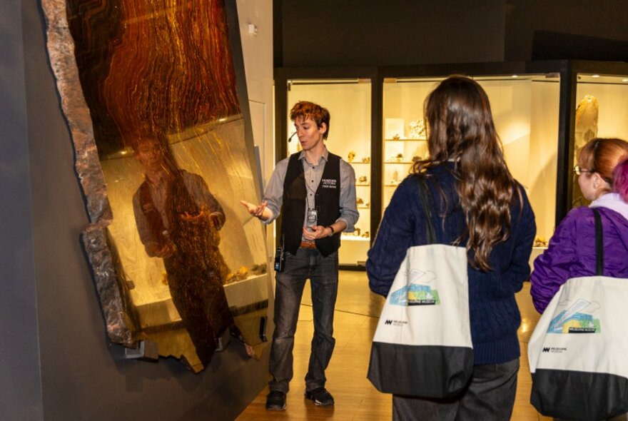 Tour participants listening to a museum guide as he talks through a display at the Melbourne Museum.