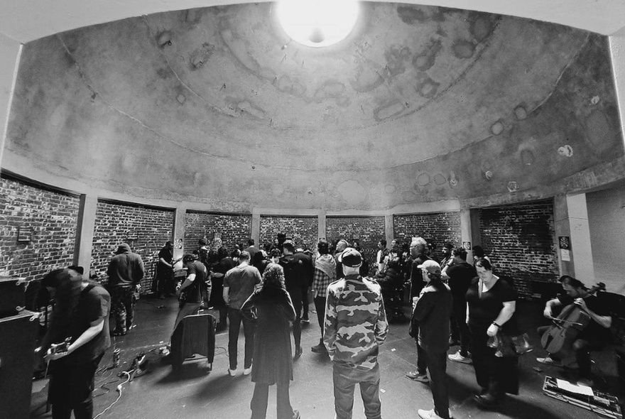 People standing in the Missions to Seafarers domed building with light pouring in through the ceiling oculus.