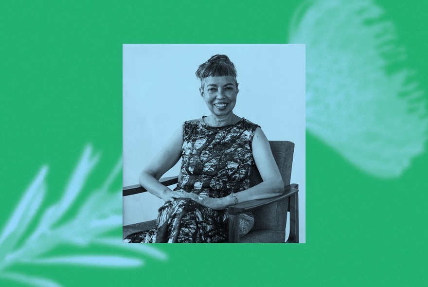 Author Michelle de Kretser smiling, seated in a chair, over an image with a green background and a white flower stem. 