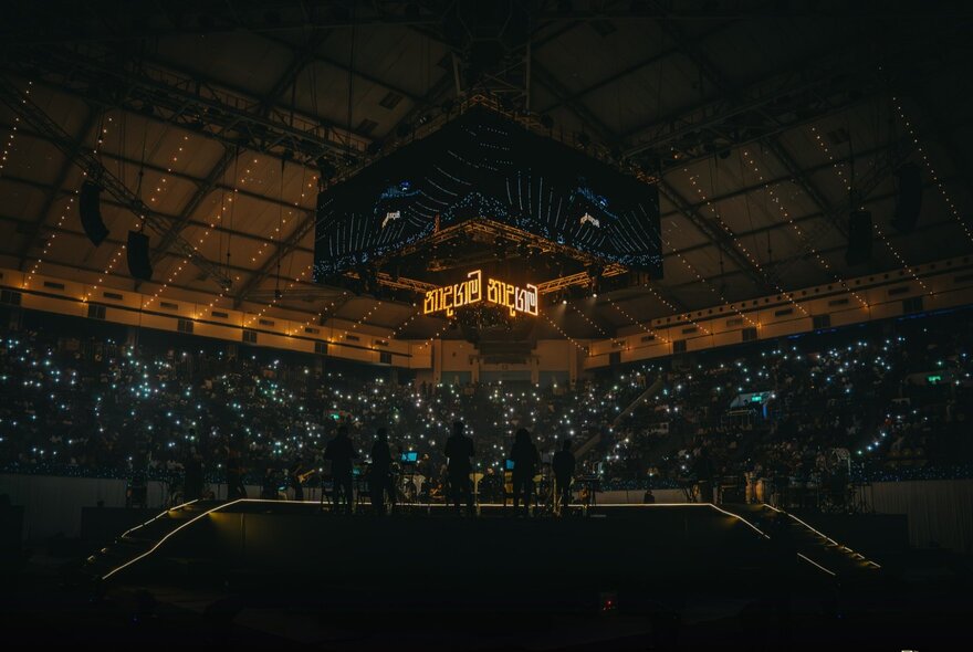 A wide-angle view of the stage at the Naadha Gama – The Orchestral Edition concert, in a covered arena.